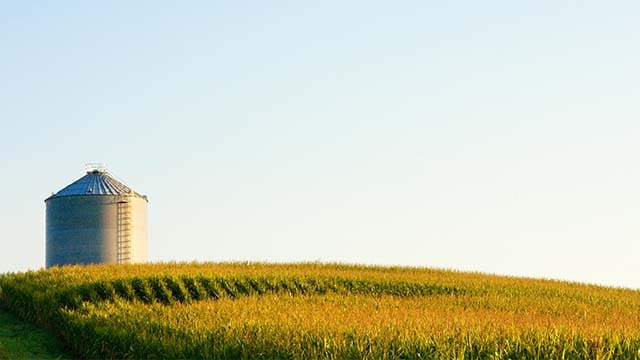 A silo on a hillside in a field